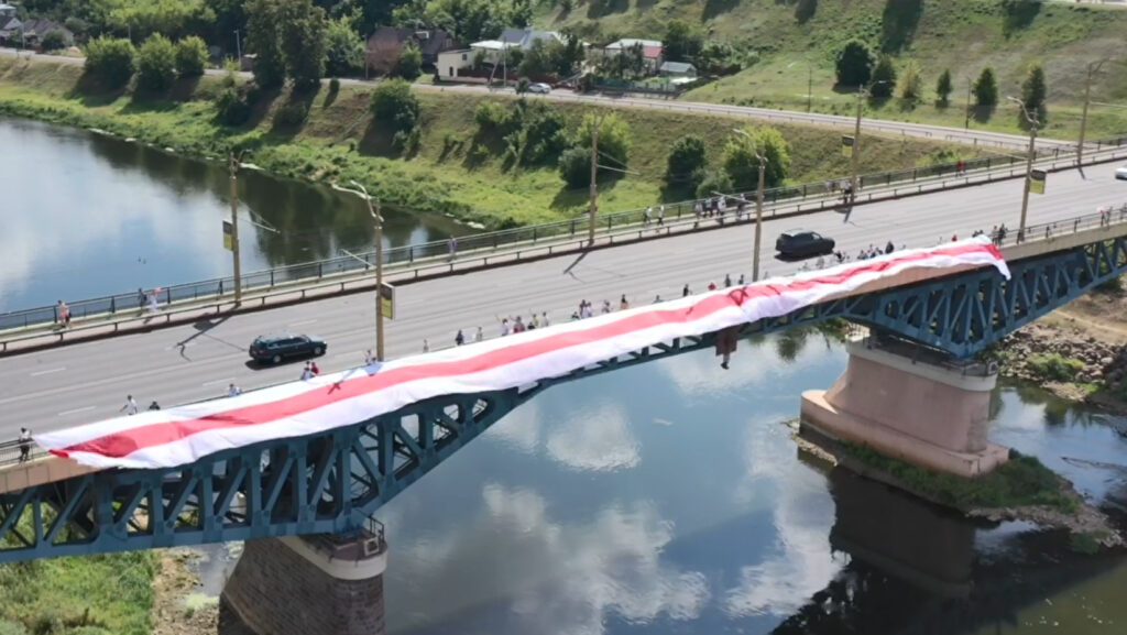 Белоруска опубликовала видео, где на секунду мелькает БЧБ-флаг. Этого хватило для суда Флаг на Старом мосту в Гродно