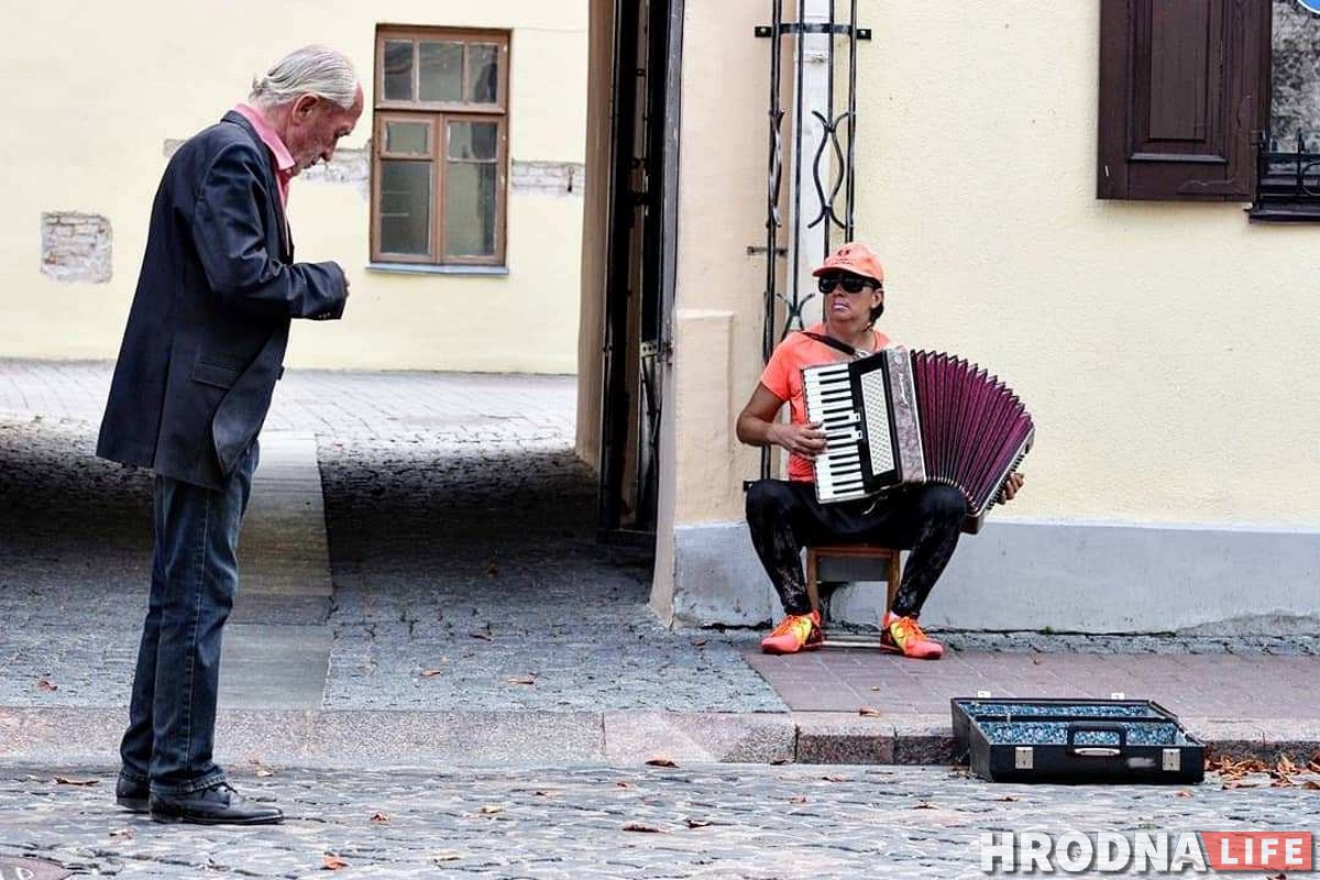 Станислав Свистун кидает деньги другому уличному музыканту - аккордеонистке Лене. Фото: Руслан Кулевич