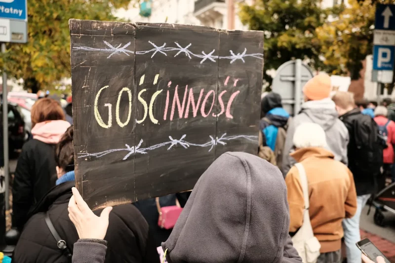 Демонстрант держит плакат "Гостепреимство". Фото демонстрации организации "Шпиля". Автор - Tomasz Swierzewski