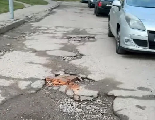 “Полнейший игнор двора”. Жители дома по улице Брикеля жалуются на разбитую дорогу в трещинах, дырах и ямах
