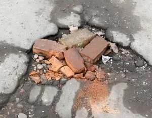 “Поўны ігнор двара”. Жыхары дома па вуліцы Брыкеля скардзяцца на разбітую дарогу ў расколінах, дзірках і ямах Яма на дороге Гродно