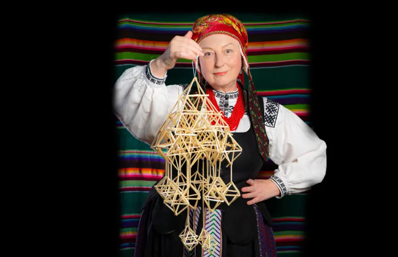 «Я шукала моцную жанчыну. А потым зразумела, што гэта я». Як эміграцыя, вышыванка і TikTok дапамаглі Ірыне зноў знайсці сябе Ірына Новік з саламяным павуком-абарэгам на фоне традыцыйнай посцілкі